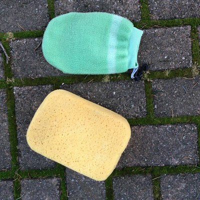 Yellow sponge and green face scrubber Yellow sponge and green face scrubber