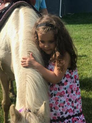 Aria hugging a pony